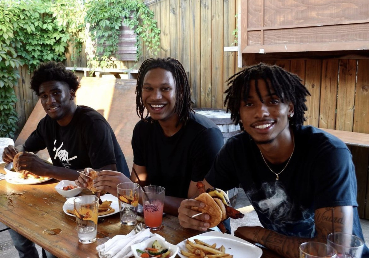 Indiana basketball sophomores Kaleb Banks (left), Malik Reneau (middle) and CJ Gunn (right) try the "Malik Reneau Burger" at Big Woods restaurant in Bloomington, Ind. 